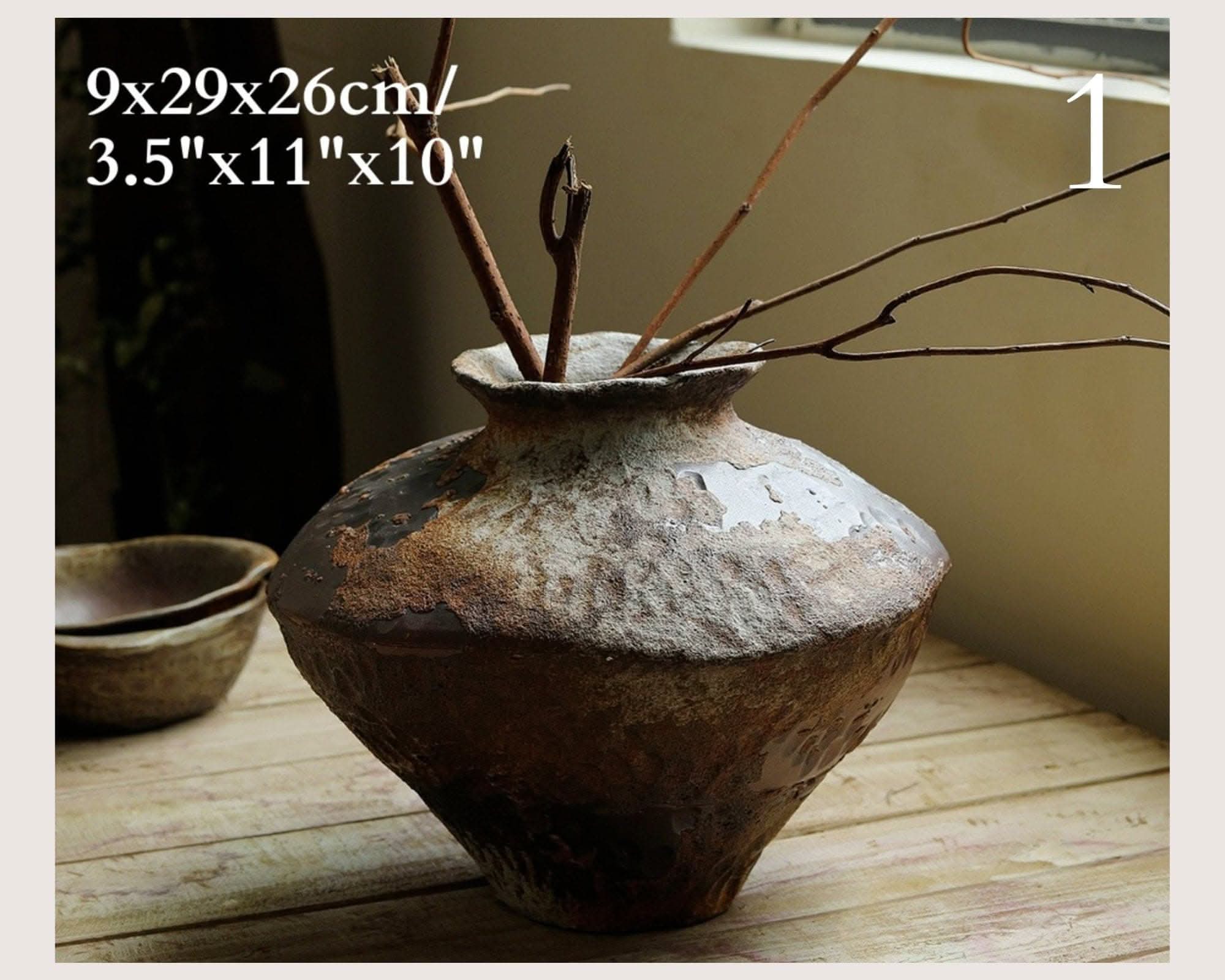 Wabi-Sabi Distressed Rustic Vase with dried branches, on rustic wood table.